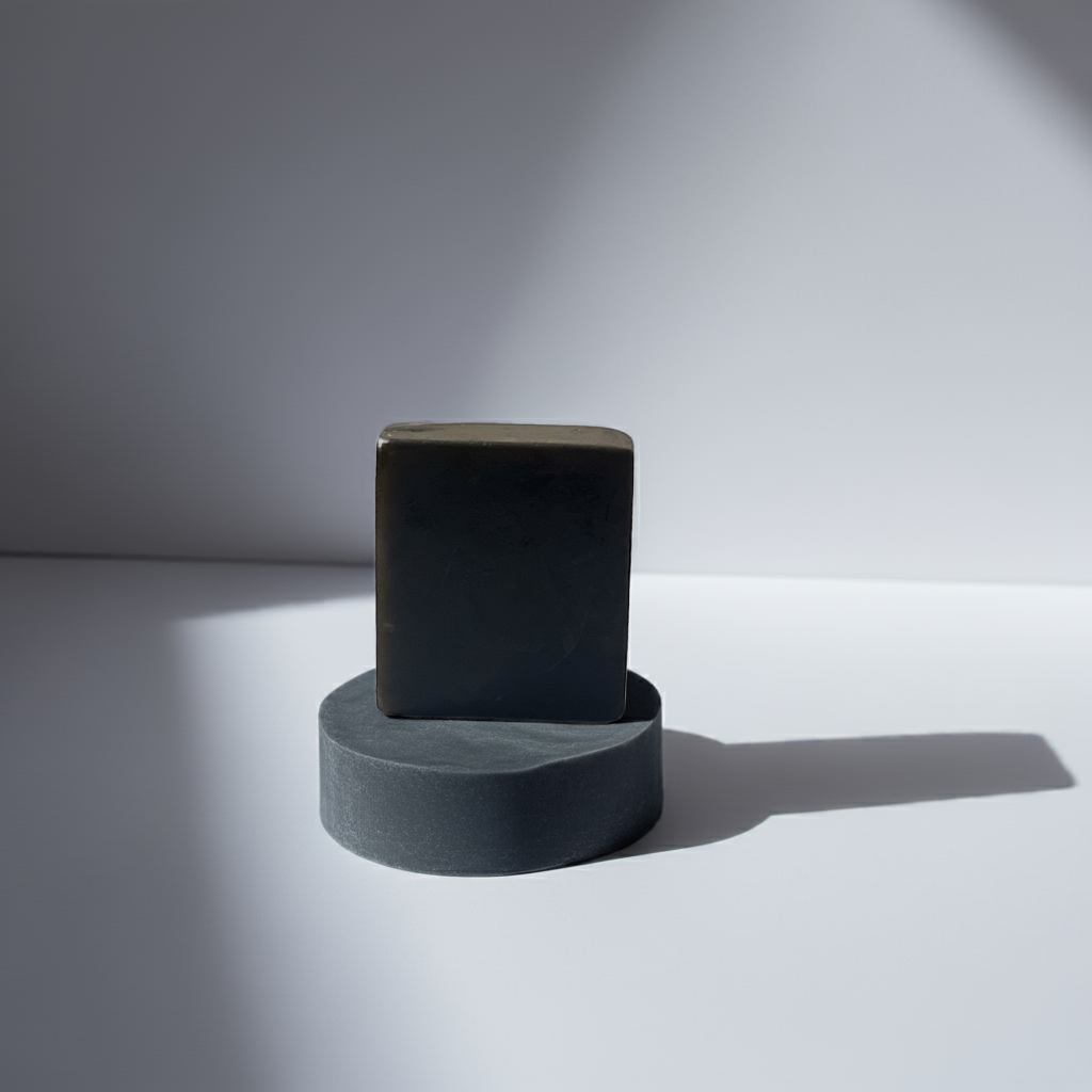 Urban Tree The Black Bar – activated charcoal soap with rich lather on a light gray surface with a soft shadow.