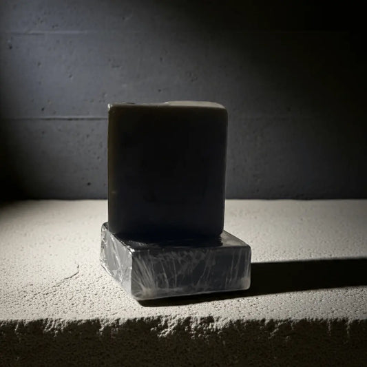Urban Tree Charcoal Activated Soap wrapped bar displayed on stone block with shadow