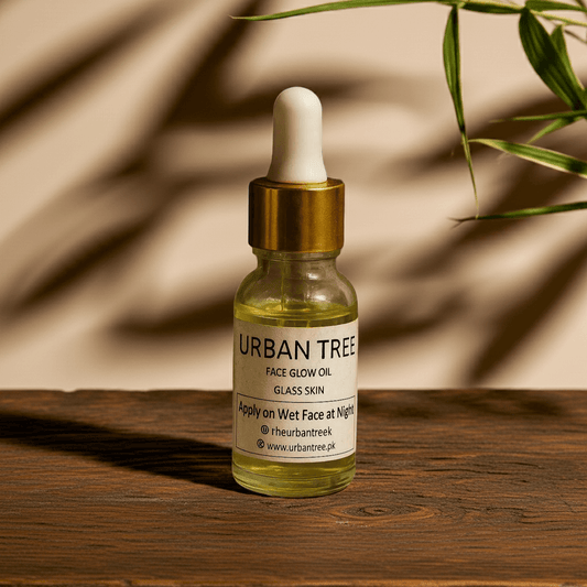 Urban Tree Face Glow Oil Glass Skin serum on wooden surface with leafy natural background – organic hydrating face oil Pakistan
