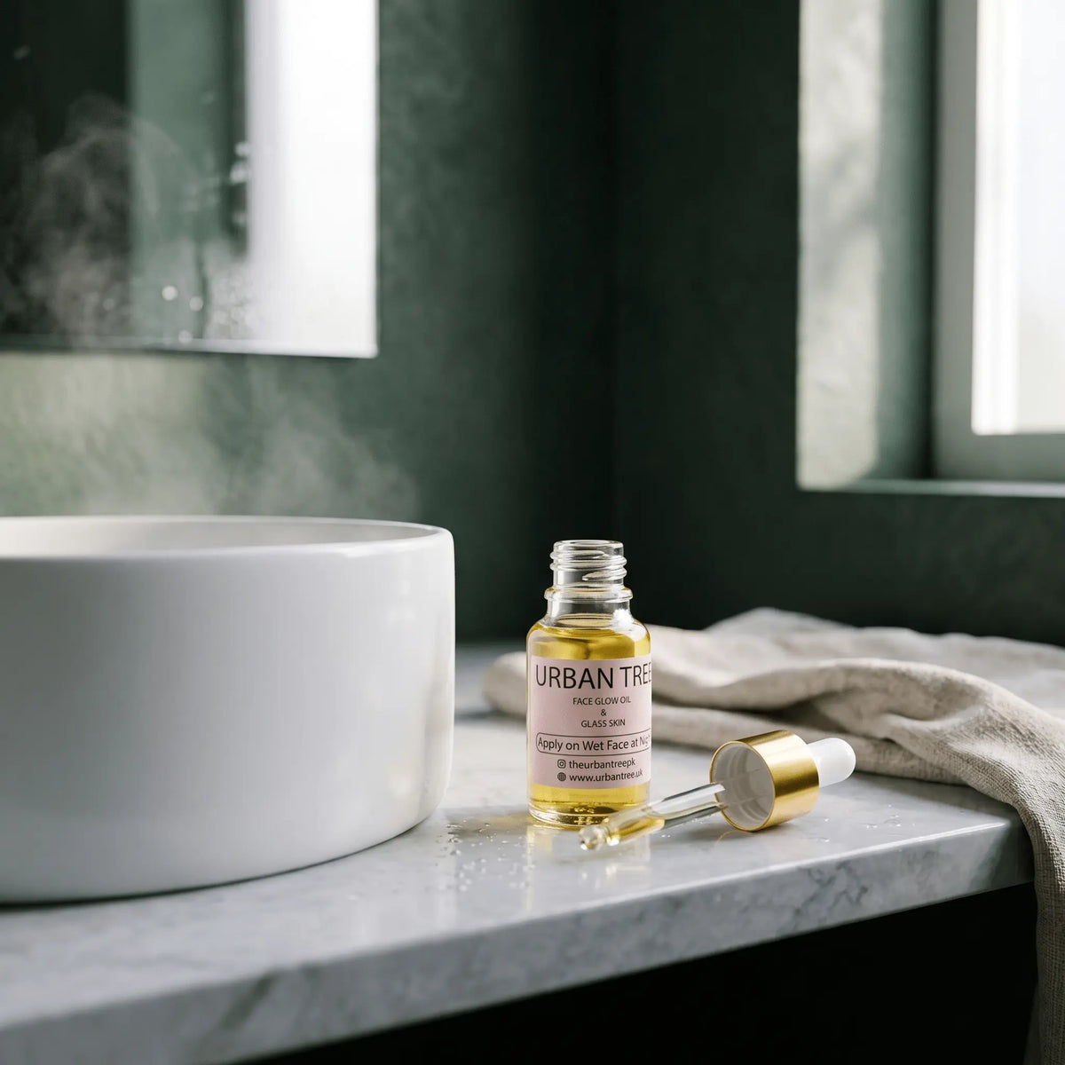 Urban Tree Glass Skin Elixir face glow oil beside a bathroom basin with its glass dropper