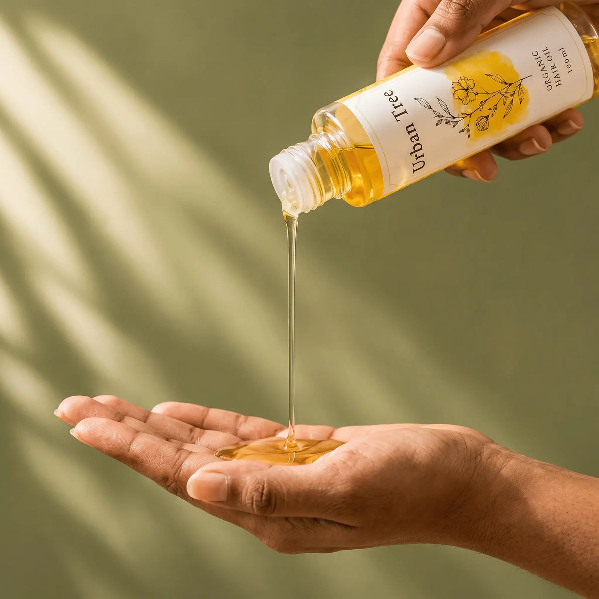 Lightweight non greasy Urban Tree Organic Hair Oil poured into a palm