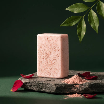 Urban Tree Acne Rescue Soap, speckled pink bar on a stone slab with rose petals and pink clay powder