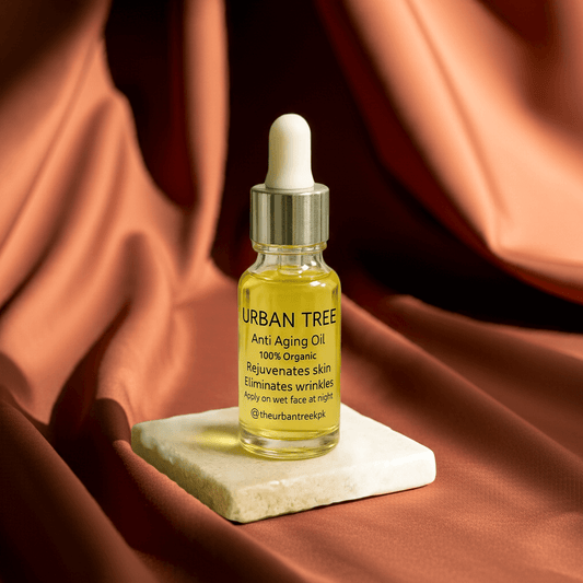 Urban Tree Anti-Aging Oil organic wrinkle care serum bottle on marble base with brown satin fabric background – natural rejuvenating face oil Pakistan