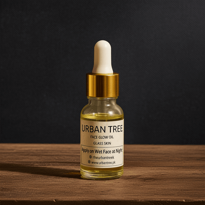 Urban Tree Face Glow Oil Glass Skin serum bottle on wooden surface with natural lighting – hydrating organic face oil in Pakistan