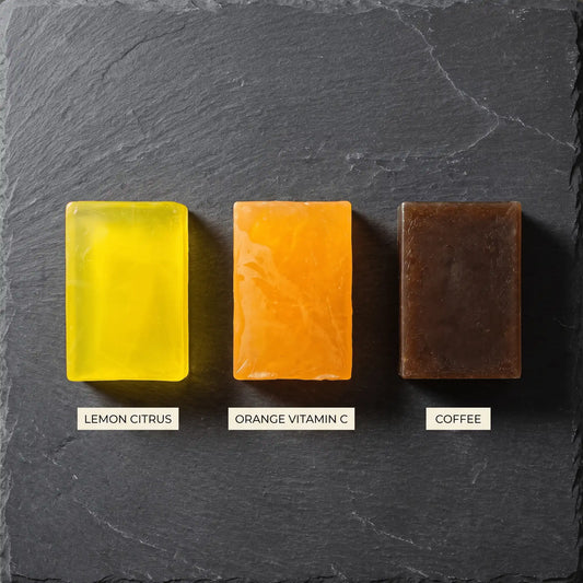 Overhead view of three Urban Tree soaps on dark slate, labelled Lemon Citrus, Orange Vitamin C and Coffee